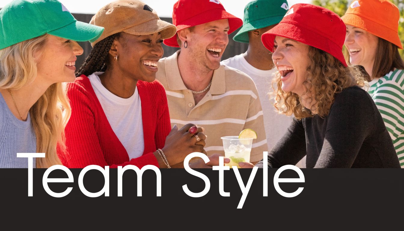 A diverse group of smiling friends wearing casual clothing and colorful hats while laughing together outdoors.