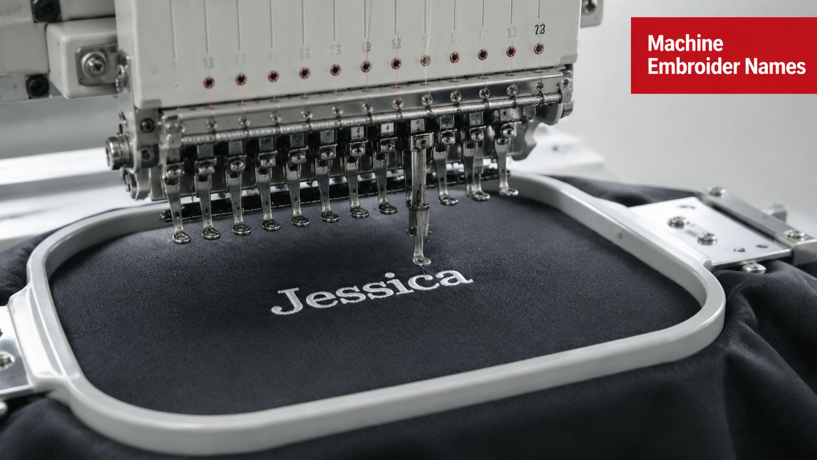 A commercial embroidery machine stitching the name Jessica onto a piece of black fabric in a hoop.