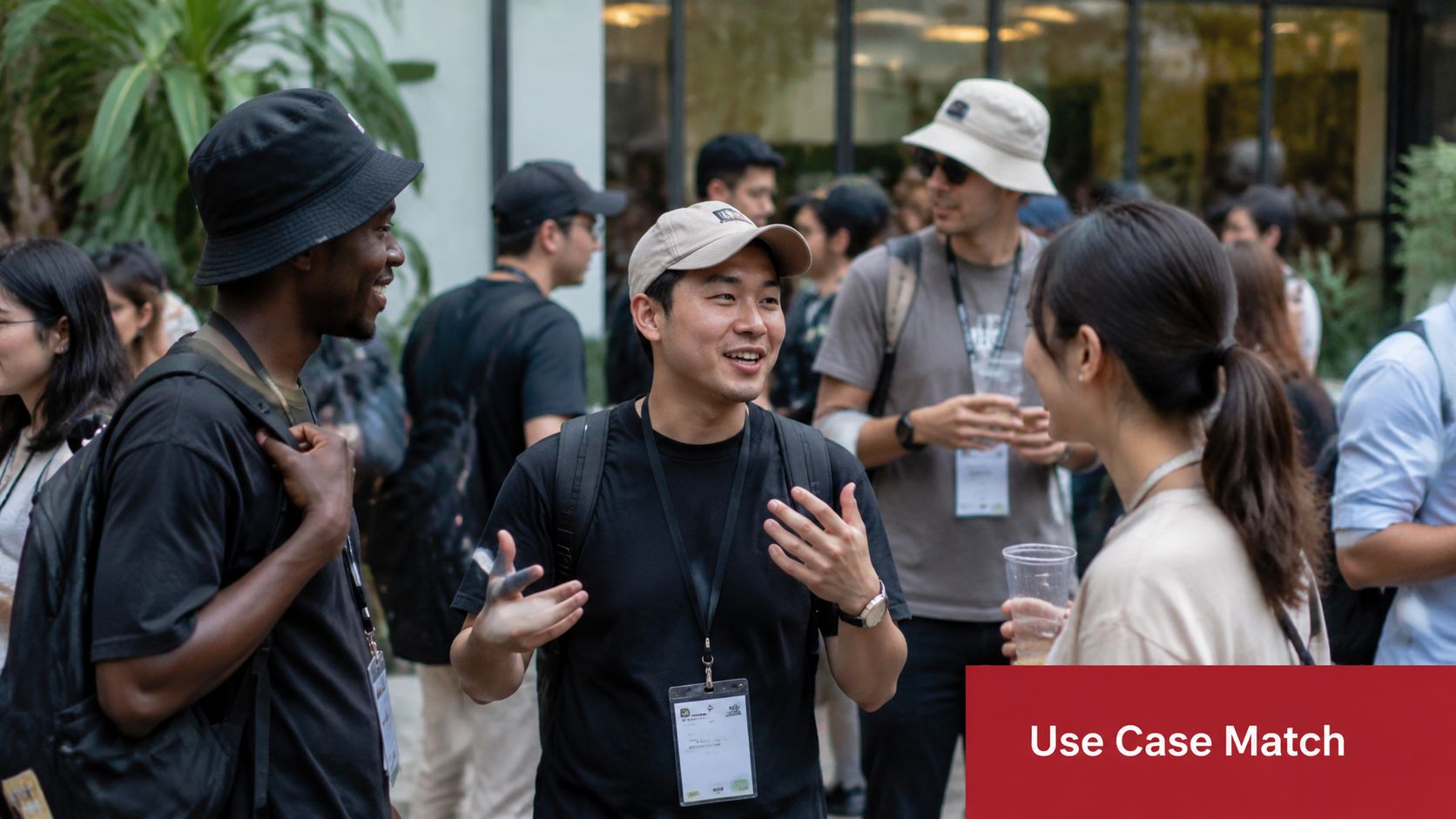 A group of young diverse people socializing at an event while wearing bucket hats and baseball caps.