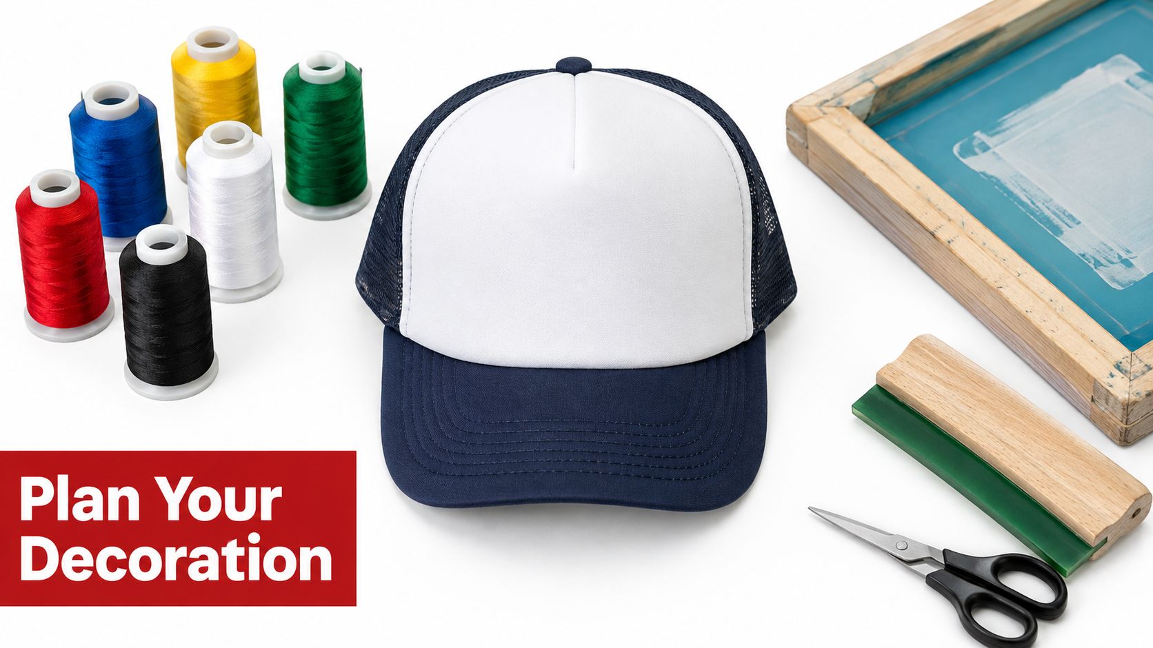 A blank white and navy trucker cap surrounded by embroidery threads, screen printing tools, and scissors.