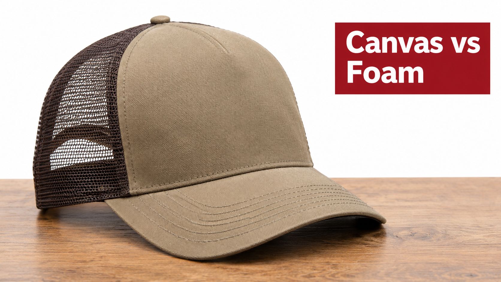A tan canvas trucker hat with a dark brown mesh back, sitting on a wooden surface.