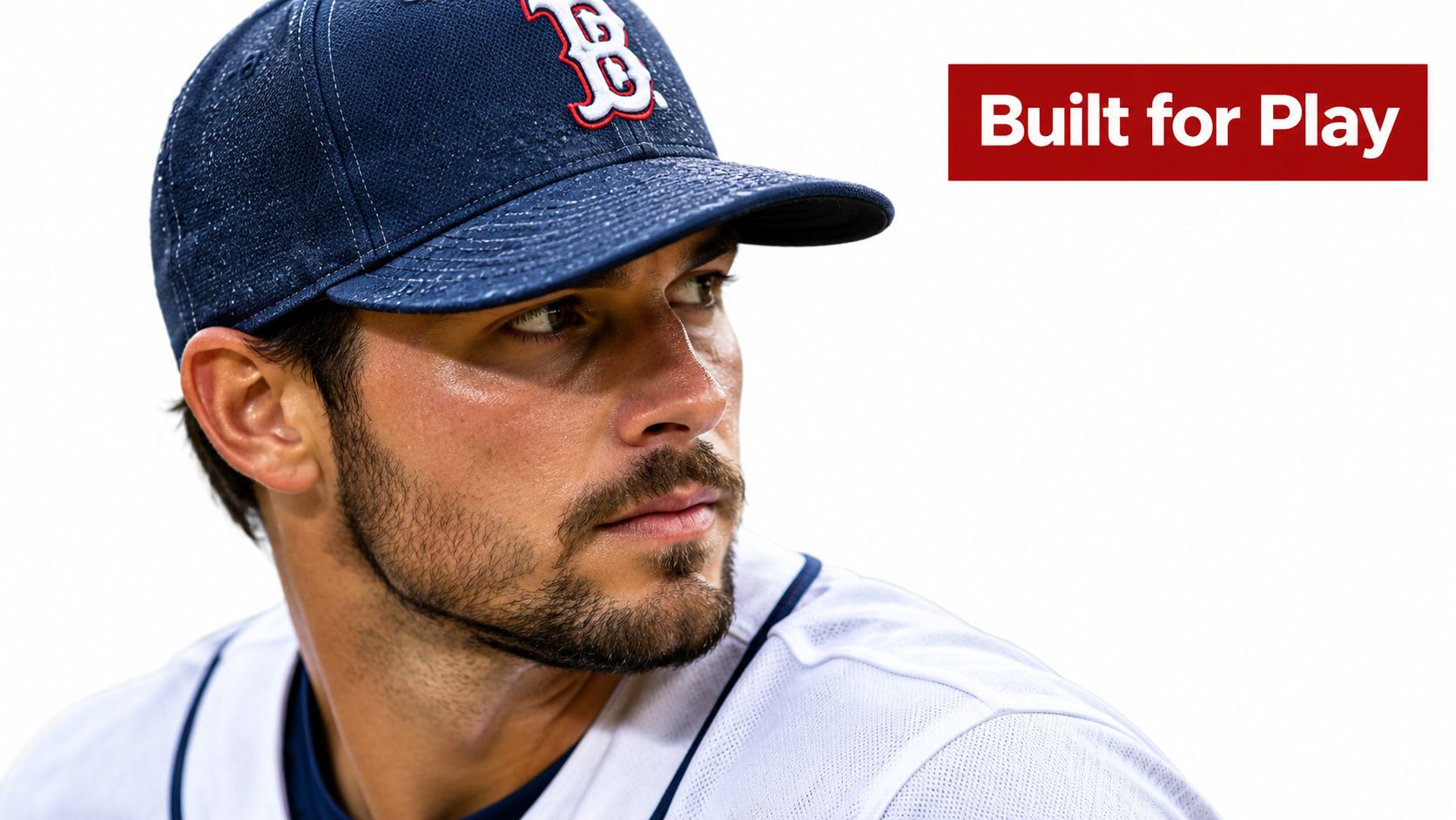 A professional baseball player wearing a navy Boston Red Sox cap looking to the side.